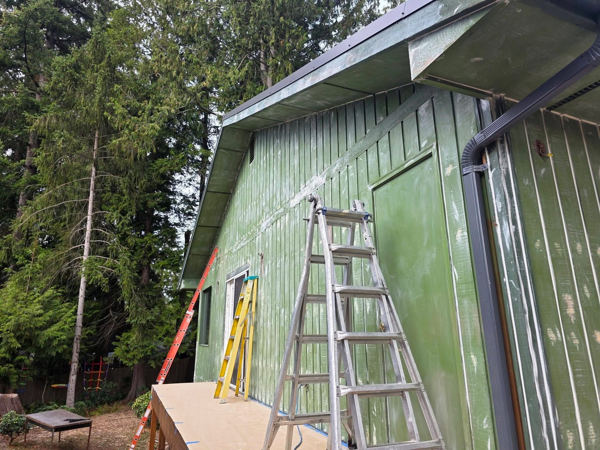 Exterior painting in progress with new architectural metal roof trim